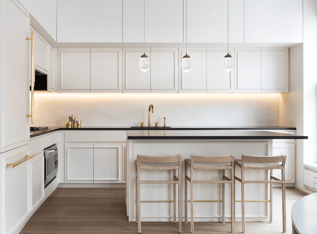 White kitchen with brass hardware and pendant lighting, project by Modoforma and Partners